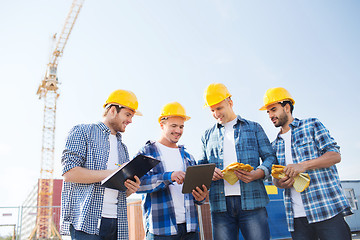 Image showing group of smiling builders with tablet pc outdoors