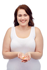 Image showing happy plus size woman in underwear with pills