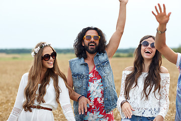 Image showing happy young hippie friends dancing on cereal field