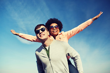 Image showing happy teenage couple in shades having fun outdoors