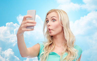 Image showing funny young woman taking selfie with smartphone