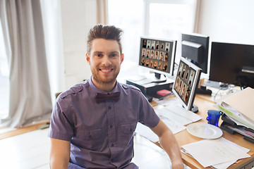 Image showing happy creative male office worker with computers