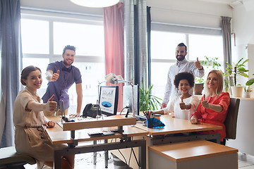 Image showing happy creative team showing thumbs up in office