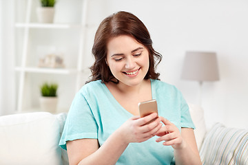 Image showing happy plus size woman with smartphone at home