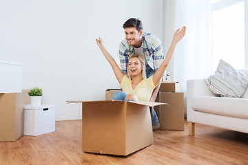 Image showing happy couple having fun with boxes at new home