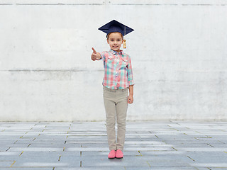 Image showing happy girl in bachelor hat showing thumbs up