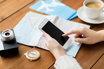 Image showing close up of traveler hands with smartphone and map