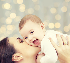 Image showing happy mother with baby over lights background