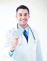 Image showing young male doctor with pack of pills