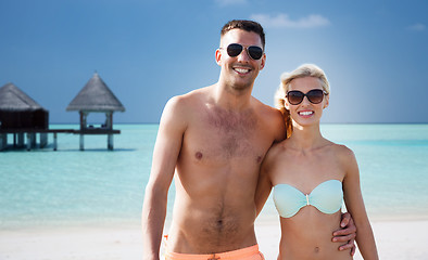 Image showing happy couple in swimwear hugging on summer beach