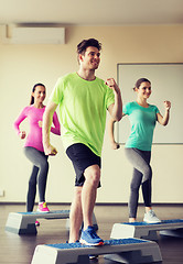 Image showing group of people working out with steppers in gym