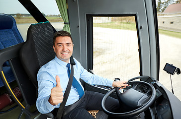 Image showing happy driver driving bus and snowing thumbs up
