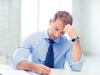 Image showing businessman writing in notebook