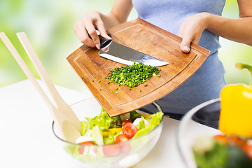 Image showing close up of woman with chopped onion cooking salad