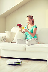 Image showing happy woman with smartphone drinking tea at home