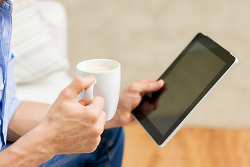 Image showing close up of man with tablet pc and tea cup at home