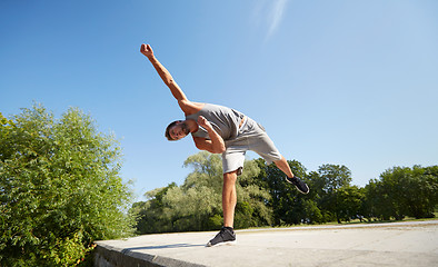 Image showing sporty young man jumping in summer park