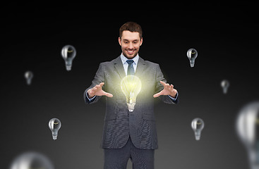 Image showing businessman working with light bulb icons