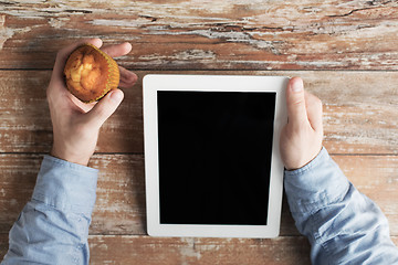 Image showing close up of male hands with tablet pc and muffin