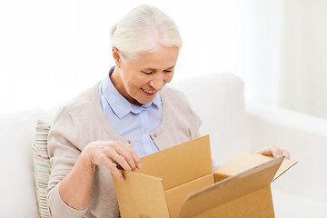 Image showing happy senior woman with parcel box at home