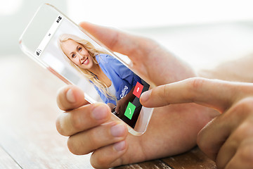 Image showing close up of male hand with transparent smartphone