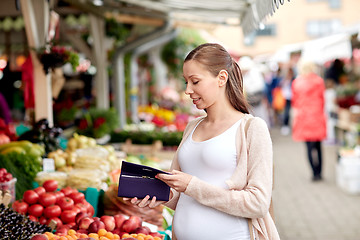 Image showing pregnant woman with wallet buying food at market