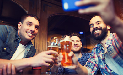 Image showing male friends with smartphone drinking beer at bar