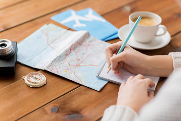 Image showing close up of traveler hands with notepad and pencil