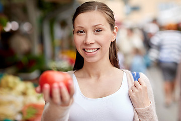 Image showing happy woman holding tomato at street market