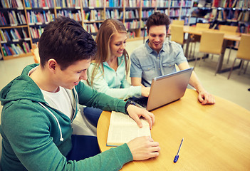 Image showing happy students with laptop and books at library