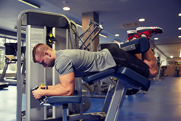 Image showing man flexing leg muscles on gym machine