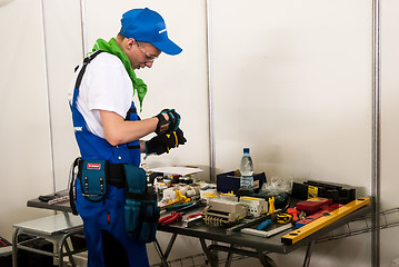 Image showing Young electrician performs task of competition