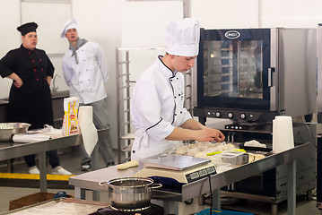 Image showing Young cook prepares food in competition