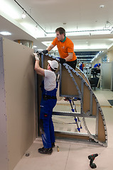 Image showing Young workers performs task with gypsum cardboard