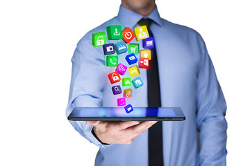 Image showing Businessman holding a tablet pc with mobile applications icons on virtual screen . Internet and business concept.