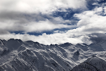 Image showing Ssnowy mountains and cloudy sky at evening