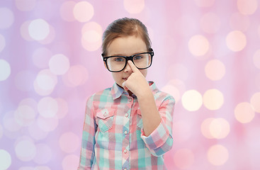 Image showing happy little girl in eyeglasses over pink lights