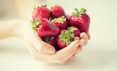 Image showing close up of woman hands holding strawberries