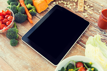 Image showing close up of blank tablet pc screen and vegetables