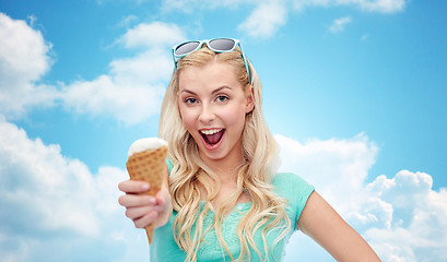 Image showing happy young woman in sunglasses eating ice cream