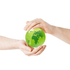 Image showing close up of hands holding green globe
