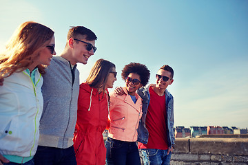 Image showing happy teenage friends walking along city street