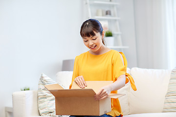 Image showing happy asian young woman with parcel box at home