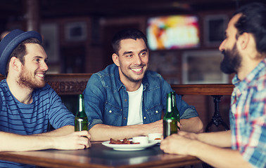 Image showing happy male friends drinking beer at bar or pub