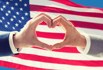 Image showing close up of male gay couple hands showing heart