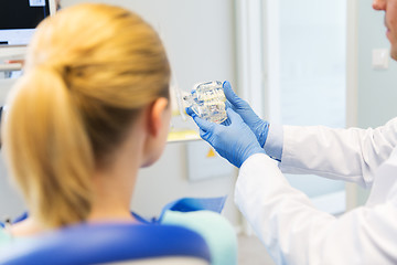 Image showing close up of dentist showing teeth model to patient