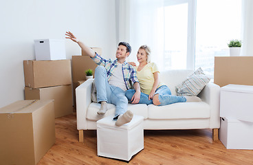 Image showing couple with boxes moving to new home and dreaming