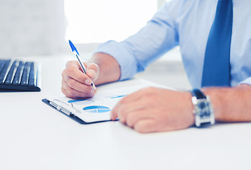 Image showing businessman working and signing papers