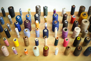 Image showing Sewing threads displayed on wooden board