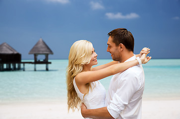 Image showing happy couple having fun over beach with bungalow